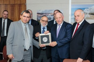 Minister Elkin presents a replica of an ancient Yerushalayim coin to Avrohom and Menachem Lubinsky – l-r Minister Zev Elkin, Avrohom Lubinsky, Menachem Lubinsky and Zev Elkin